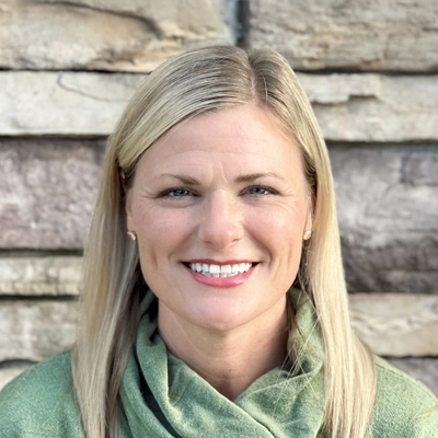 Julie smiling in a green shirt.