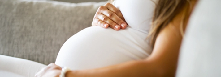 A pregnant woman holding her belly.