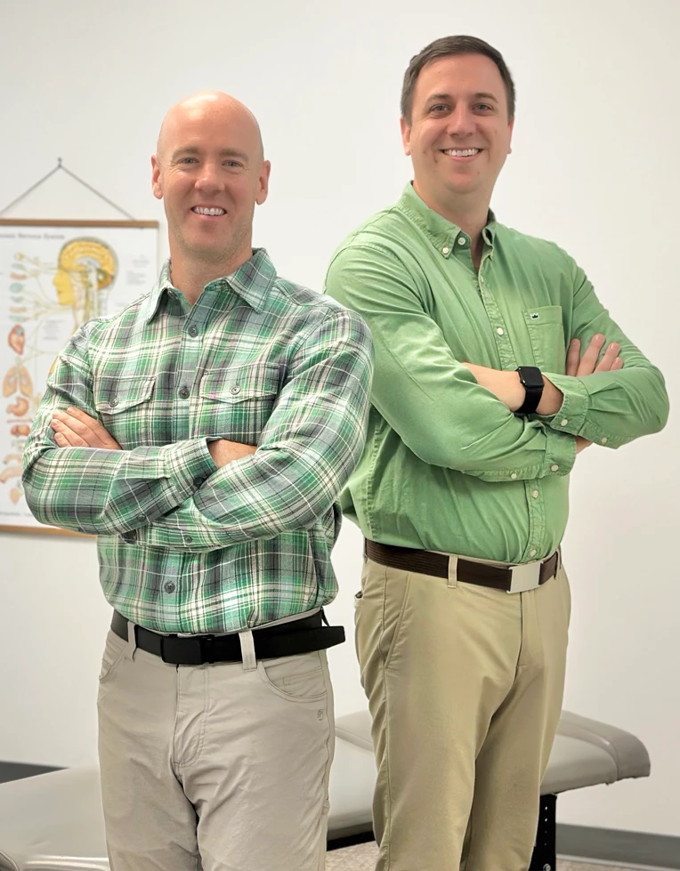 Dr. Jason Barker, D.C. & Dr. Andrew Green, D.C. smiling while wearing green.