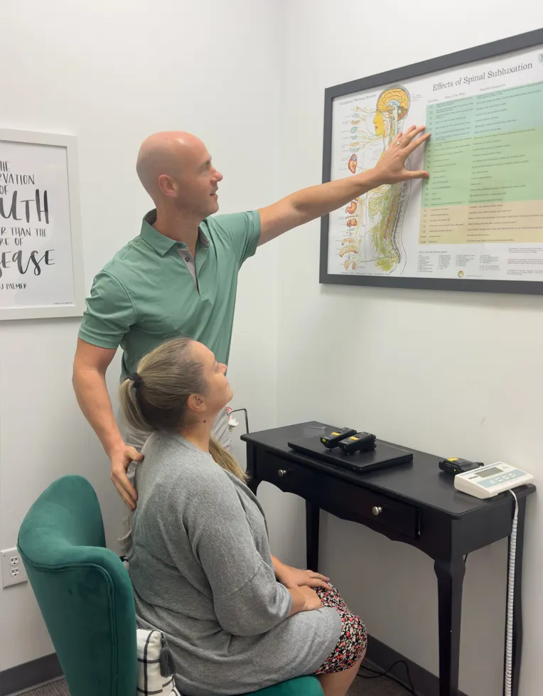 Dr. Jason Barker teaching a patient about spinal subluxation.