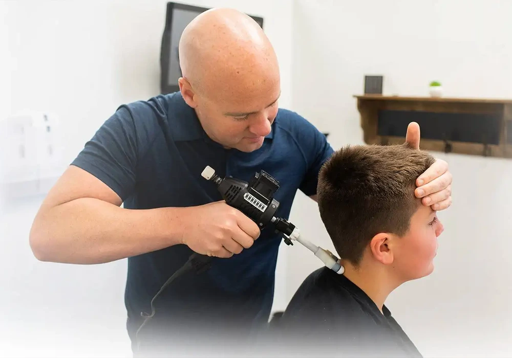 Chiropractor Jason Barker Adjusting A Patient With Device